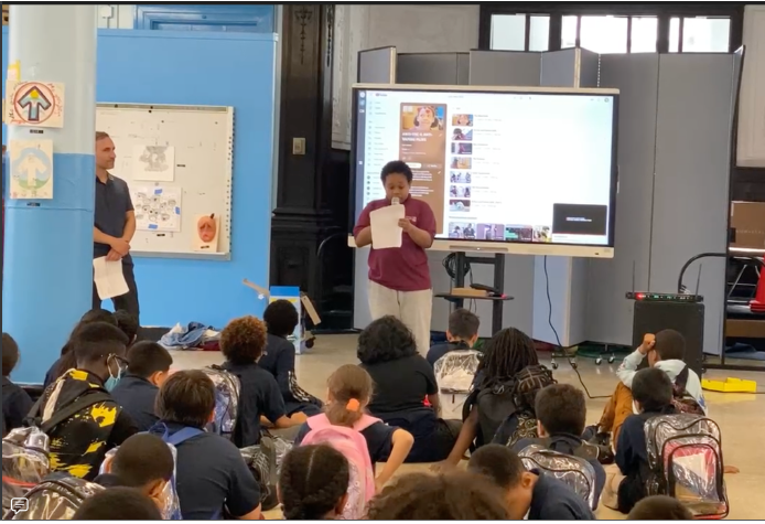 A person standing in front of a classroom with a projector screen AI-generated content may be incorrect.